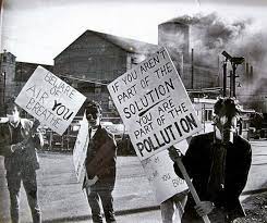 People standing in front of a polluting factory