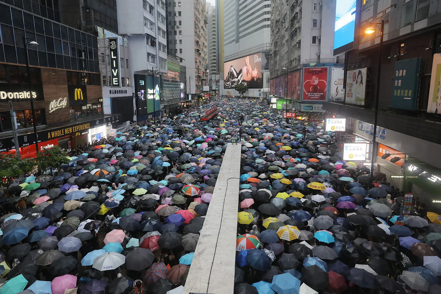 A crowd of people in Hong Kong carrying umbrellas.